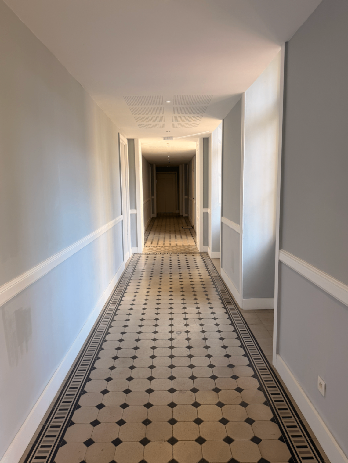 Elegant heritage corridor with black and ivory tiled floor