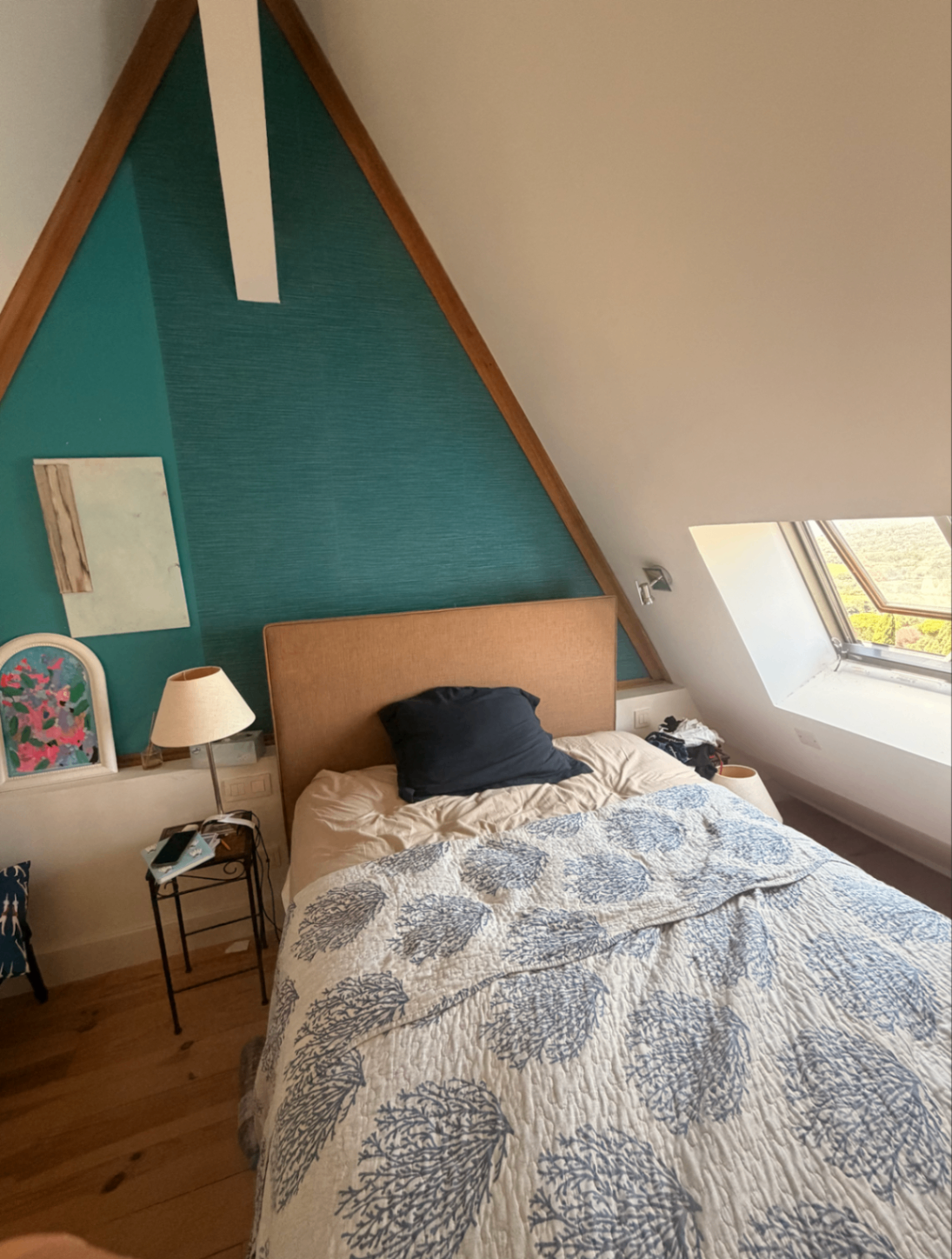 Bedroom with teal accent wall and skylight over the vineyards