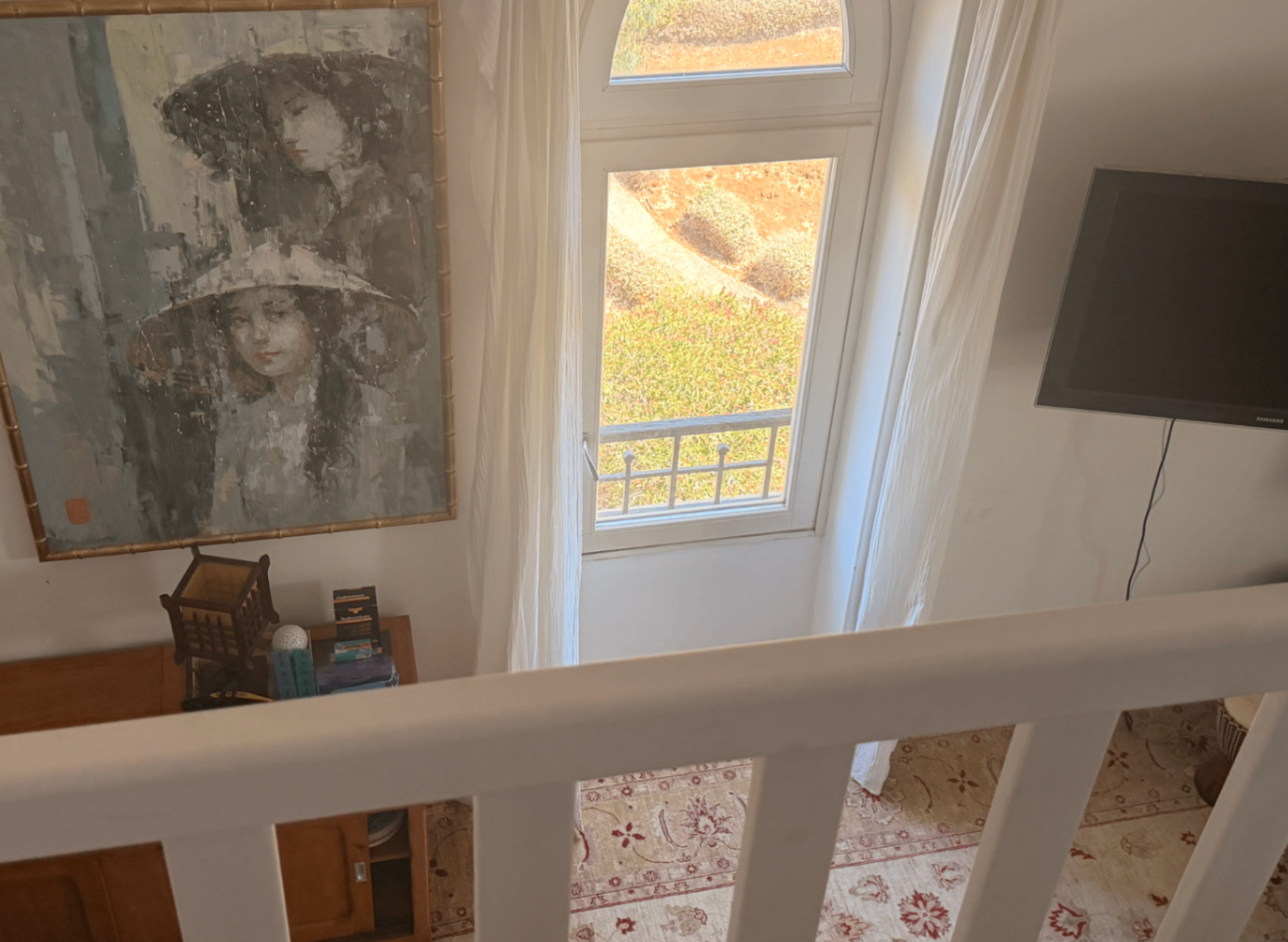 Landing window over the garden with framed portrait