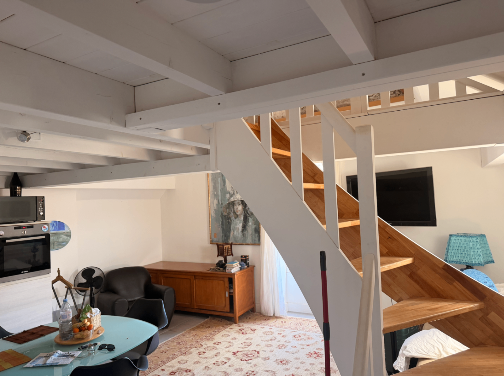 Living area detail with wood staircase and beamed ceiling